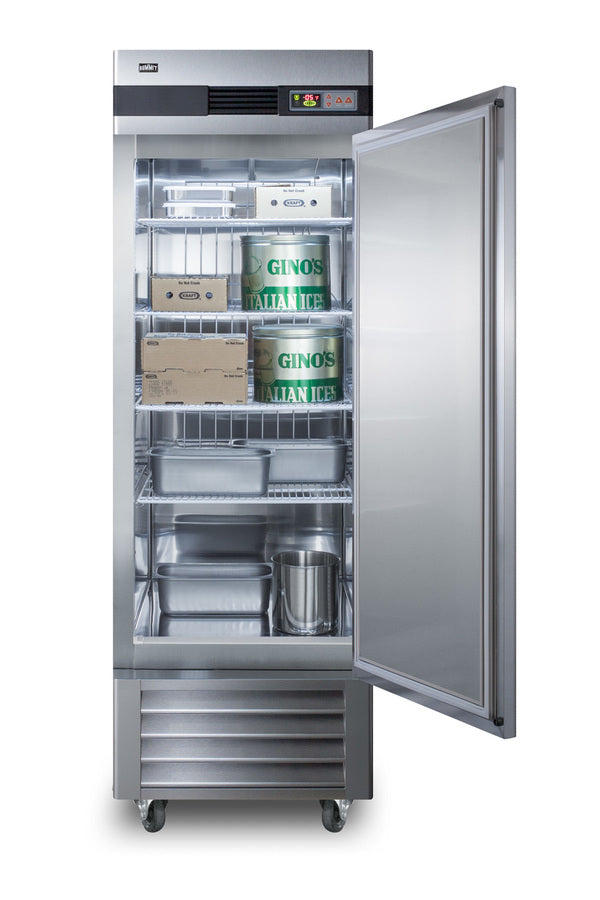 A commercial upright stainless steel freezer with an open door reveals shelves holding two large Gino’s Italian Ice containers, a cardboard box, metal pans, and an ice bucket. The interior of this reach-in freezer is well-lit, with a digital temperature display at the top.
