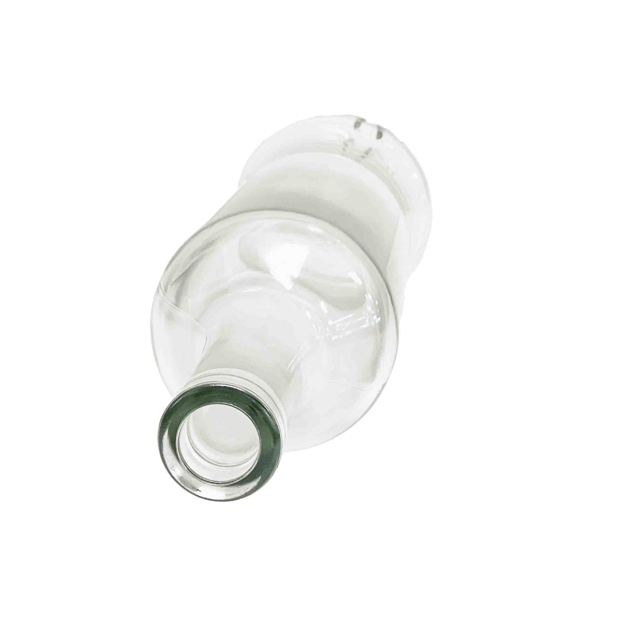 A clear, empty oil & vinegar bottle is pictured lying on its side atop a white background. The mouth of the glass bottle faces the viewer, showing its circular opening, while the rest gradually blurs into the background.