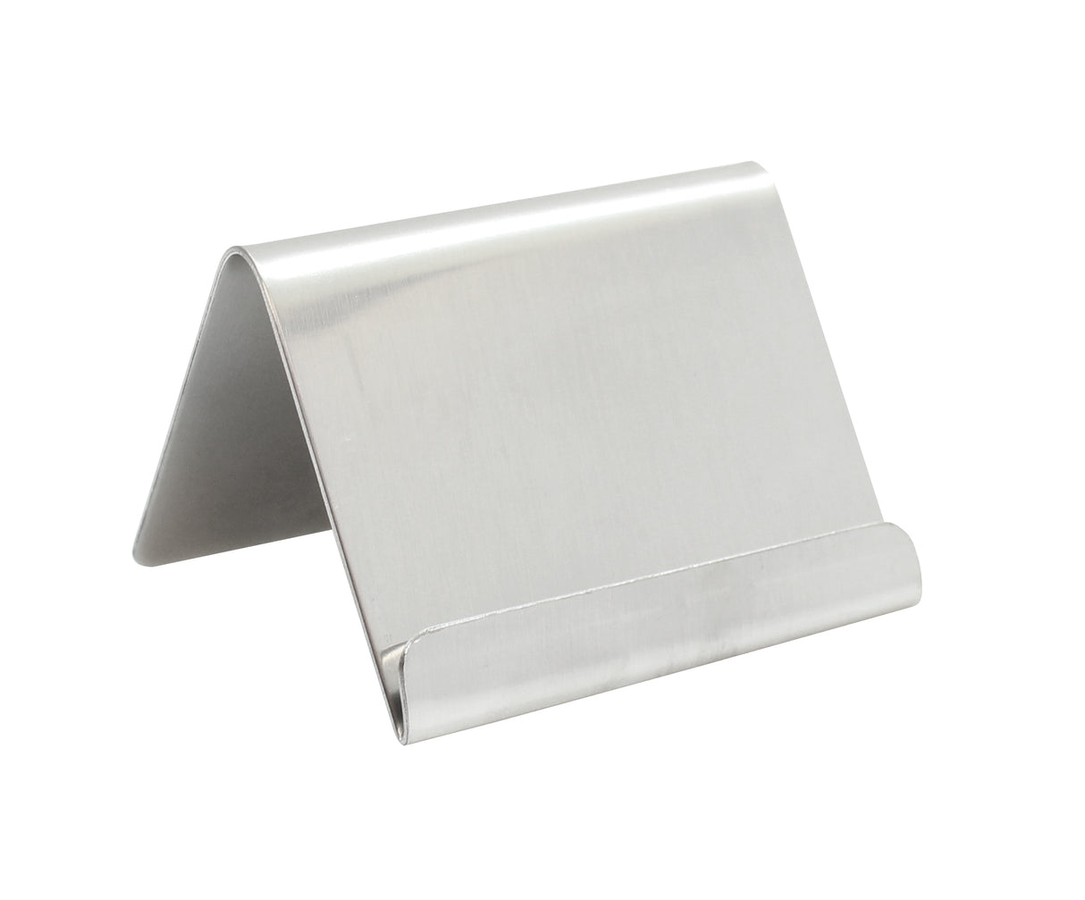 A silver, L-shaped stainless steel stand with a smooth brushed finish. Its minimalist design features a slanted back for support and a raised lip, making it an ideal card holder or phone stand for any flat surface.