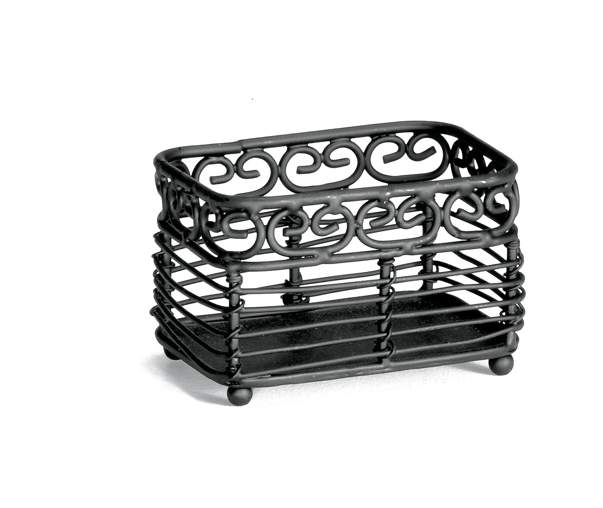 A rectangular, black metal basket from the Mediterranean Collection by TableCraft, featuring decorative swirl patterns. This sturdy Sugar Packet Holder has an open, slatted design with small round feet and is photographed on a white background.
