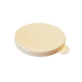 A round, off-white plastic replacement dredge lid with small holes evenly distributed across the surface, used for straining or draining. A small tab extends from one edge for easy lifting. Universal and dishwasher safe. Background is plain white.