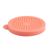 A round, flat, pink silicone drain cover with many small holes arranged in concentric circles. Featuring a small tab for easy lifting, this universal cover is dishwasher safe and photographed on a white background.