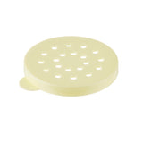 A round, flat, light yellow plastic object with multiple evenly spaced holes and a small tab on one edge, ideal as a Replacement Dredge Lid for cheese or spices. This item is dishwasher safe and photographed on a white background.