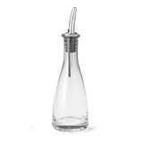 A clear glass oil & vinegar bottle with a slightly tapered neck, featuring a stainless steel pourer with a curved tip and black rubber seal. The bottle is empty and set against a white background, ideal for dispensing olive oil or vinegar.