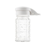 Clear, ribbed glass jar with a white plastic flip-top lid, shown upright against a plain white background. Moisture proof and dishwasher safe, the jar is empty, displaying its textured surface and transparency. Ideal as a salt/pepper shaker.
