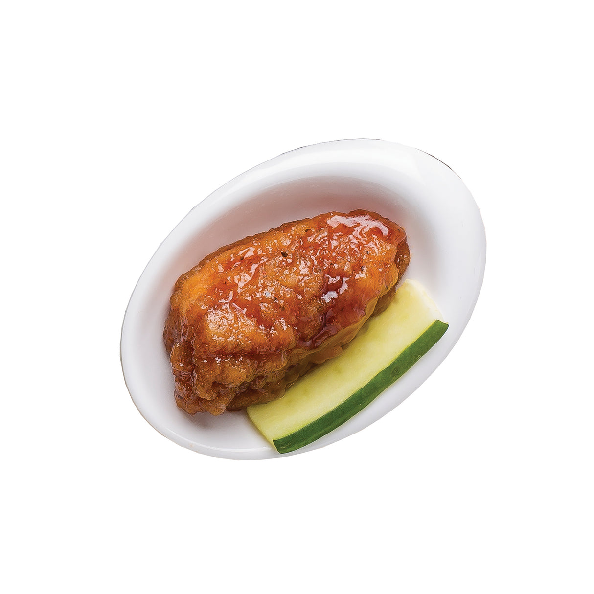 A glazed fried chicken wing with a shiny reddish-brown sauce sits on a white oval plate, accompanied by a slice of cucumber and a mini melamine bowl. The background is plain white; all serveware is dishwasher safe.