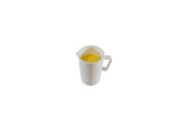 A Sierra Collection Creamer by TableCraft Products, crafted from durable melamine, sits centered on a plain white background. The white pitcher with a handle is viewed from above, revealing a small amount of yellow liquid inside.