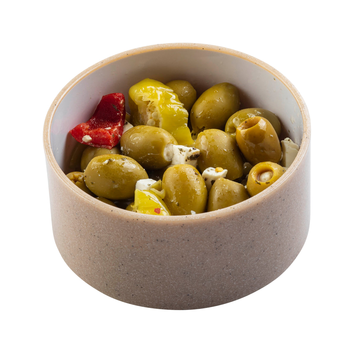 A beige, stackable bowl filled with green olives, red and yellow pepper pieces, and chunks of white cheese, all marinated, on a white background.