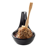 A single meatball sits in a glossy black melamine mini spoon with a small amount of brown sauce. A bamboo pick is inserted in the meatball, topped with a thin slice of garlic or onion, all set against a white background and fully dishwasher safe.