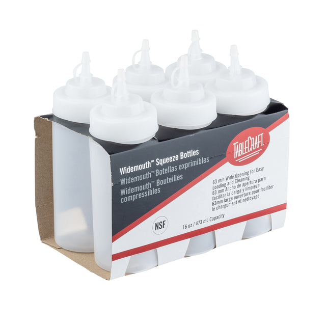 Six empty, clear polyethylene WideMouth Squeeze Bottles with white caps are held in a brown cardboard holder. The label highlights features like dishwasher safe and 16 oz (473 ml) capacity. Bottles are upright in two rows.
