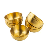 Six gold brushed serving bowls are grouped together on a white background. Three bowls are nested in a stack on the left, while three more are slightly tilted and stacked on the right, their stainless steel surfaces smooth and polished, reflecting light beautifully.