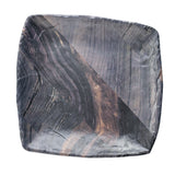 A square ceramic serving tray with rounded edges features a glossy, marbled barnwood pattern in dark brown and black tones, resembling natural wood grain or polished stone. The white background highlights the plate’s unique swirling texture.