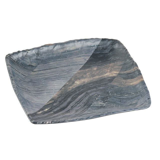 A rectangular ceramic serving tray with gently curved edges, featuring a marbled pattern in dark blue, gray, and white tones. The surface has a textured, wavy appearance, and the plate is photographed on a white background.