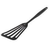 A black Fish Turner slotted spatula with a long silicone handle and four wide slots on the flat, triangular blade, designed for flipping or lifting food. The handle has a small hanging hole. The spatula rests on a plain white background.