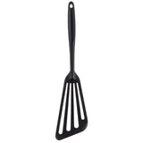 A black Fish Turner with a stainless steel core and a long silicone handle. The triangular, slightly angled head has three wide slots, perfect for flipping or serving food. A small hole at the end of the handle allows easy hanging.