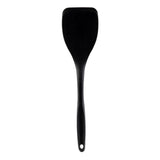 A black spatula with a wide, flat head and a long, narrow silicone handle featuring a small hole for hanging. The spatula is positioned vertically on a plain white background.