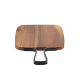 A square wooden cutting board with rounded edges, featuring a flat metal handle attached with two visible screws on each side—reminiscent of the Industrial Collection Serving Paddle—set against a plain white background.