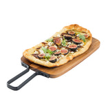 A rectangular flatbread pizza topped with sliced figs, arugula, and crumbled cheese sits on an acacia serving paddle with a metal handle, isolated on a white background. The crust is golden brown and slightly puffed.