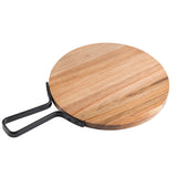 A round acacia serving paddle with a light, natural finish and visible wood grain. It features a black metal handle extending outward in a rectangular loop for easy gripping or hanging. The surface is clean and smooth.