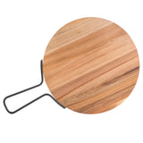 A round acacia serving paddle from the TableCraft Products Industrial Collection features striking light and dark wood grain patterns and a bold black metal handle bent into a unique, angular shape, displayed on a white background.