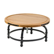 A round coffee table with a light wood top and raised edge, supported by a black metal frame. With four curved legs and circular braces, its central metal bolt gives it the sturdy charm of an industrial cake stand.