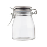 A small, empty clear glass spice jar with a wide mouth and a resealable stainless steel clamp lid. The lid features a metal hinge and latch mechanism, and the clean jar sits upright on a white background with no label or content inside.