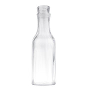 A clear, empty glass carafe with a wide base, narrow neck, and fitted glass stopper. The 1-1/2 qt cylindrical bottle curves outward at the shoulders and stands upright against a plain white background.