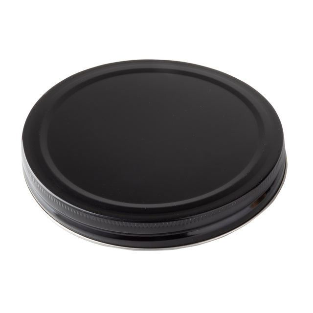 A black, round, metal replacement lid with a smooth top surface and ribbed edges, viewed from an angle against a white background. Suitable for sealing jars or as a TableCraft beverage dispenser lid, it appears unused and clean.