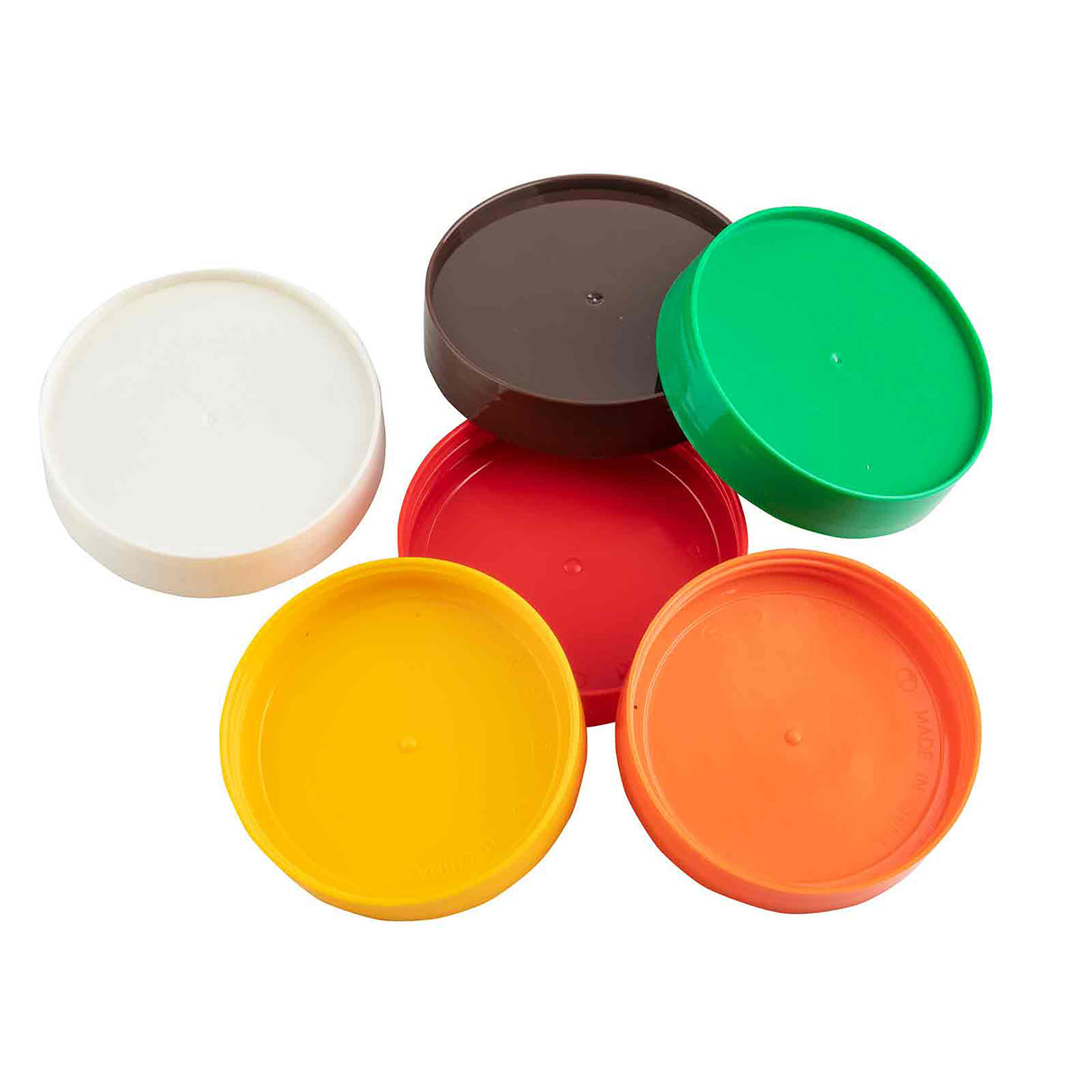 Six round plastic lids from the TableCraft Replacement Cap Set—white, brown, green, red, yellow, and orange—are arranged in a loose circle on a white background. These colorful lids are compatible with PourMaster bottles.