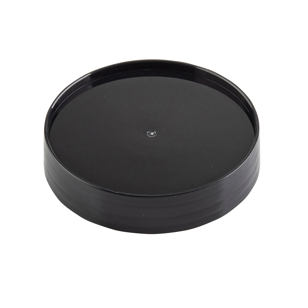 A black, round, plastic Replacement Cap with a slightly raised edge and glossy finish, photographed on a white background. This TableCraft pour lid is plain and smooth, featuring a small circular indentation in the center.