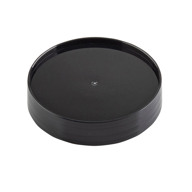 A black, round, plastic Replacement Cap with a slightly raised edge and glossy finish, photographed on a white background. This TableCraft pour lid is plain and smooth, featuring a small circular indentation in the center.