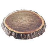 A realistic, round cushion designed to look like a tree trunk cross-section, featuring detailed wood grain rings on top and bark texture on the sides, mimicking the natural look of a TableCraft platter.
