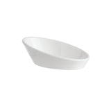 A small, white, oval-shaped mini bowl with a slightly tilted, slanted edge, placed on a plain white background. The dish appears empty and features a minimalist, modern design that is dishwasher safe.