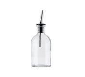 A clear glass bottle with a stainless steel pourer and black rubber stopper, typically used as an oil & vinegar bottle, is shown upright against a plain white background. The empty bottle is cylindrical in shape.