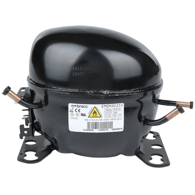 A black, dome-shaped refrigerator compressor with two mounting brackets at the base, labeled “Embraco.” Featuring copper pipes on each side and a warning label, it is a key component in Empura Refrigeration systems. The surface is glossy and industrial.