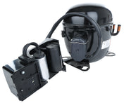 The E-EGM-23FB Compressor for Empura Refrigeration features a black cylindrical design with attached electrical components, capacitor, and wiring on a metal base. Two copper pipes extend from one side and a protective cover shields the terminal connections.