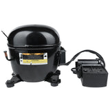 A black, dome-shaped Empura Refrigeration compressor with warning labels is mounted on four feet. To the right, it connects to an attached electrical component with black cables. The metal surface is shiny against a plain white background.