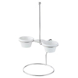 A sleek metal stand with a circular base and vertical rod holds two white ceramic bowls in ramekin holders on opposite sides. The minimalistic design features a shiny stainless steel finish, and the bowls are removable for easy serving.