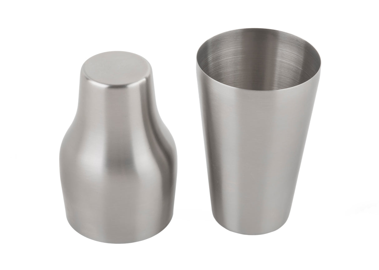 Two stainless steel cocktail shaker pieces are shown side by side on a white background. The left piece is inverted, showing its flat base, while the right stands upright revealing its smooth 20 oz cylindrical interior and brushed metallic finish.