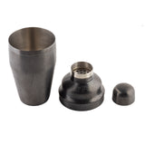 A three-piece black stainless steel cocktail shaker disassembled: the large 18 oz cup on the left, the middle strainer lid with small holes in the center, and the small cap on the right, all on a white background.