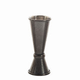 A TableCraft Japanese Jigger with a textured, hammered finish. Crafted from stainless steel, it features two conical measuring cups in an hourglass shape and a shiny metallic interior—perfect for precise cocktail mixing.