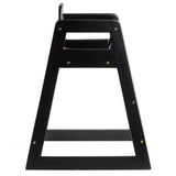 A black wooden high chair is shown from the side. The sturdy, minimalist design features an A-shaped wood frame, visible screw fastenings, and a footrest bar at the bottom. Its simple seat and backrest highlight practical elegance.