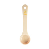 A beige polycarbonate measuring spoon viewed from above, marked with yellow text showing 1 oz, 30 ml, and 2 tbsp on the handle. The NSF-certified spoon is clean, empty, and centered on a white background.