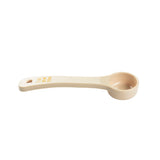 A beige polycarbonate measuring scoop with a round bowl on one end and a flat handle on the other. The handle features yellow measurement markings reading “1/2 CUP 125 mL” and a small hole at the end for hanging. NSF certified.