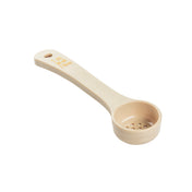 A beige perforated polycarbonate spoonout measuring spoon with a flat handle and round, perforated bowl. Yellow text on the handle reads “1-2 oz 2 TBSP.” NSF certified, it has a hole for hanging. The background is plain white.