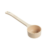 A beige polycarbonate spoon features a long handle and small holes in the bottom of the cup, designed for straining. This NSF perforated spoonout has a textured grip and a hole at the end for hanging, shown against a white background.