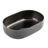 An aluminum oval bowl with a textured, mosaic-like exterior and a hammered, shiny black powder coat finish inside. This modern TableCraft bowl features slightly high sides and is photographed empty against a white background.