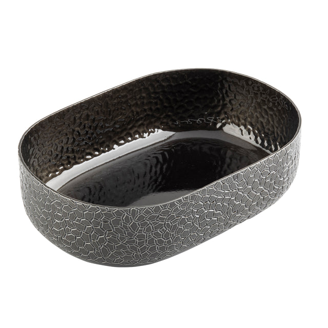 An aluminum oval bowl with a textured, mosaic-like exterior and a hammered, shiny black powder coat finish inside. This modern TableCraft bowl features slightly high sides and is photographed empty against a white background.