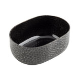 An aluminum oval bowl with a glossy black powder coat finish inside and a textured, crackle pattern gray exterior. Its irregular geometric surface gives this modern piece a stylish look. The empty bowl is shown on a white background.