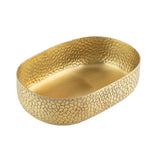 An aluminum oval bowl with a hammered, textured surface and reflective gold powder coat finish. Its elegant pebble-like pattern adds decorative charm, while the bowl sits empty on a white background.